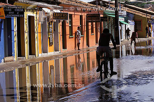  Colored houses in the historical center of Porto Seguro * with the flooded street for the water of the rain and man passing of bicycle - south coast of Bahia - Brazil  * The Costa do Descobrimento (Discovery Coast site - Atlantic Forest Reserve) is  