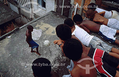  Soccer - Boy plays with a ball and other boys watches him in a 