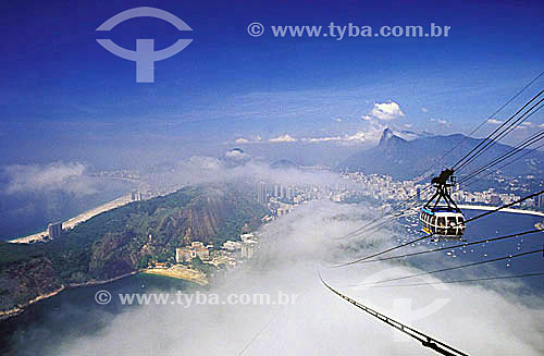  Cloudy View of the neighborhoods of Botafogo, Copacabana, and Urca as seen through clouds from Sugar Loaf Mountain, with the Sugar Loaf cablecar and the statue of Cristo Redentor (Christ the Redeemer) in the distance - Rio de Janeiro city - Rio de J 