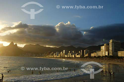  People at Ipanema Beach with buildings and  Morro Dois Irmaos (Two Brothers Mountain)* in the background - Rio de Janeiro city - Rio de Janeiro state - Brazil  * The two Brothers Mountain is National Historic Sites since 08-08-1973. 