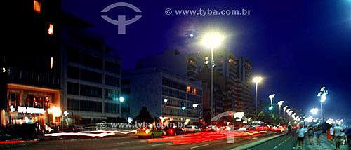  Night falls on Ipanema neigborhood as some people walk on the Promenade, with the lights of cars moving along Av. Vieira Souto (Vieira Souto Avenue) to the left - Rio de Janeiro city - Rio de Janeiro state - Brazil 