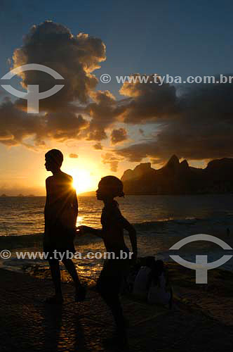  Silhouette of two people walking along Ipanema Beach at sunset - Rio de Janeiro city - Rio de Janeiro state - Brazil 