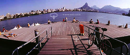  Panoramic view of Rodrigo de Freitas Lagoon with people at a pier with the Gavea Rock and 