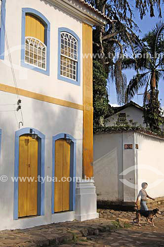  Woman walking her dog out in the streets of Paraty town - Rio de Janeiro state - Brazil 