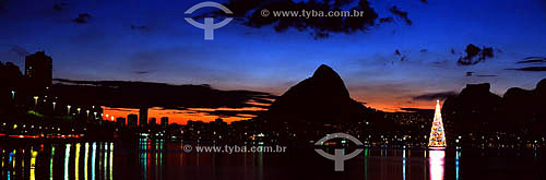  Lagoa Rodrigo de Freitas (Rodrigo de Freitas Lagoon) (1) at sunset, with the Christmas tree - the lights from buildings reflected on its surface, and the silhouettes of Morro Dois Irmaos (Two Brothers Mountain) and Rock of Gavea (2) in the backgroun 