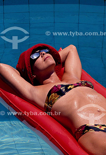  Women wearing biquini and sunglasses floating in the swimming pool 