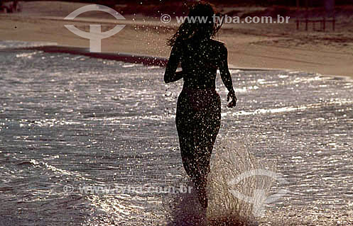  Silhouette of a woman  running on the beach  