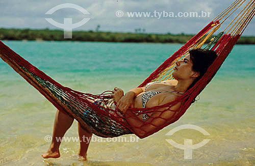  Women relaxing in a hammock on the beach 