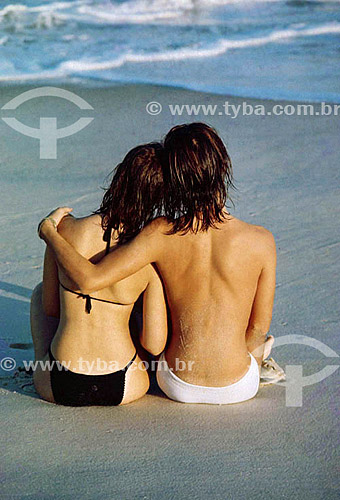  Couple seates at the beach looking to the sea 