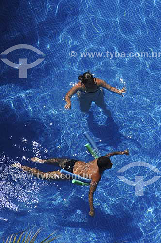  Woman and man with buoy at swimming pool - Melia Hotel - Maceio city - Alagoas state - Brazil - March 2006 