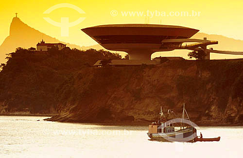  Contemporary Art Museum (MAC) with the Christ the Redeemer in the background and a typical fishermen boat in the foreground - Niteroi - Rio de Janeiro state - Brazil 