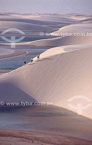  People walking across sand dunes - Lençois Maranhenses - Maranhao state - Brazil 
