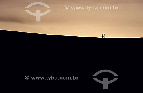  Couple walking across sand dunes 