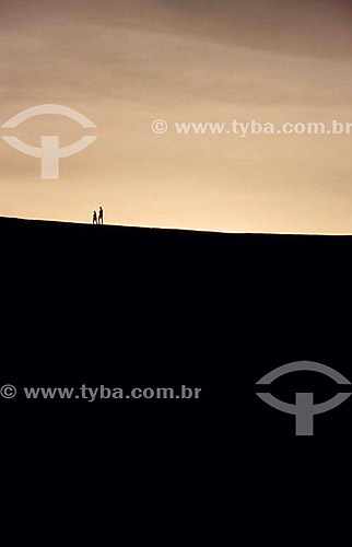  Couple walking across sand dunes 