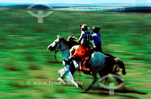  Two men riding their horses on prairie 