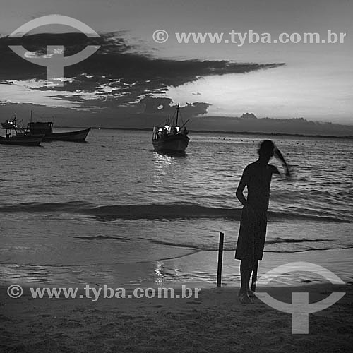  Silhouette of a boy at the beach with boats on the sea in the background - Guaratiba Beach, at the south coast  of Rio de Janeiro city, near the Restinga da Marambaia (Marambaia Coastal Plain) - Rio de Janeiro city - Brazil 