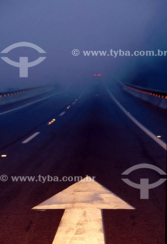  Detail of a directional arrow painted on a foggy highway - Brazil 