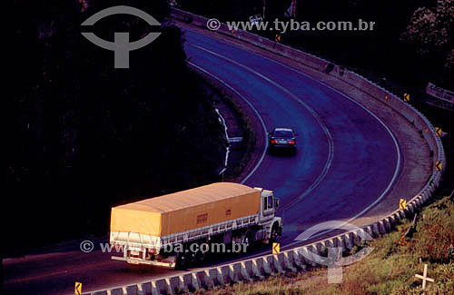  A car and a truck moving along a curve on a highway - Brazil 