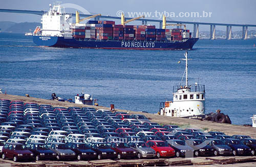  Cars waiting to be loaded for export in Rio de Janeiro Seaport, with cargo ship and the Rio-Niteroi Bridge in the background - Rio de Janeiro city - Rio de Janeiro state - Brazil 