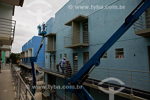  Subject: Growth Acceleration Program (Programa de Aceleracao do Crescimento - PAC) aim to improve the countrys infrastructure - worker painting a building of Candominio Itaoca Housing - Complexo do Alemao  / Place:  Rio de Janeiro city - Rio de Jan 