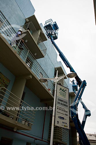  Subject: Growth Acceleration Program (Programa de Aceleracao do Crescimento - PAC) aim to improve the countrys infrastructure - worker painting a building of Candominio Itaoca Housing - Complexo do Alemao  / Place:  Rio de Janeiro city - Rio de Jan 