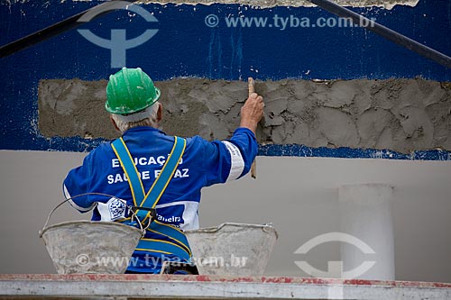  Subject: Growth Acceleration Program (Programa de Aceleracao do Crescimento - PAC) aim to improve the countrys infrastructure - worker painting a building of Candominio Itaoca Housing - Complexo do Alemao  / Place:  Rio de Janeiro city - Rio de Jan 