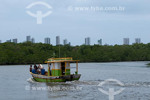  Subject: Boat on the Capibaribe river next to the mangrove of Ilha de Deus (Deus Island), with the buildings of Boa Viagem beach in the background  / Place:  Recife city - Pernambuco state - Brazil  / Date: 14/10/2010 