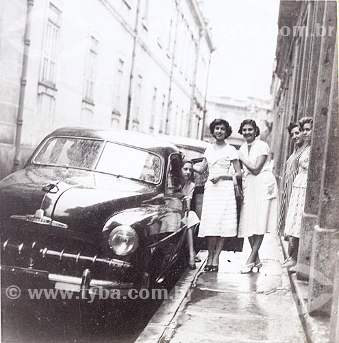  Young women pose for a photograph next to the car Chevrolet Styleline De Luxe at Leandro Martins Street with the Pedro II College to the left - Camera Rolleiflex - (editorial use)   - Rio de Janeiro city - Rio de Janeiro state (RJ) - Brazil