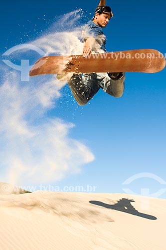  Man practicing sandboarding in the dunes of Joaquina Beach  - Florianopolis city - Brazil