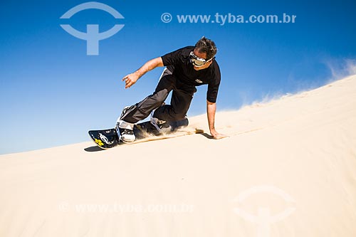  Man practicing sandboarding in the dunes of Itapiruba Beach  - Imbituba city - Brazil