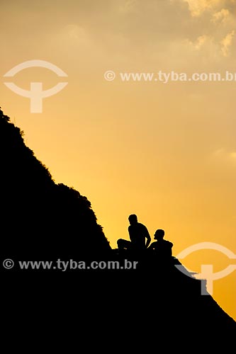  Subject: Youths sitting on stone of hill Sugar Loaf near the sea / Place: Urca neighborhood - Rio de Janeiro city - Rio de Janeiro state (RJ) - Brazil / Date: 01/2014 