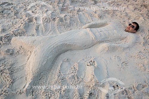  Man buried in the sand with the body as a mermaid - Grande Beach (Big Beach) - Thiago de Oliveira Mendes (for editorial use)  - Arraial do Cabo city - Brazil