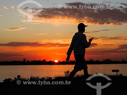  Man walking on the banks of Guaiba Lake during sunset  - Porto Alegre city - Rio Grande do Sul state (RS) - Brazil
