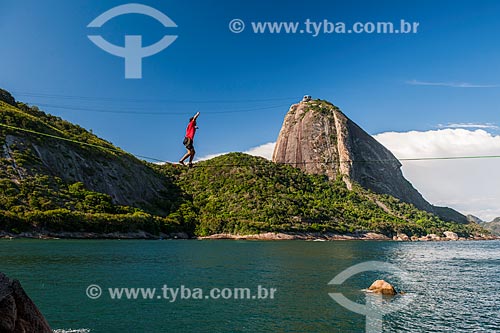  Practitioner of slackline - hill near to Vermelha Beach (Red Beach) with Sugar Loaf in the background  - Rio de Janeiro city - Rio de Janeiro state (RJ) - Brazil