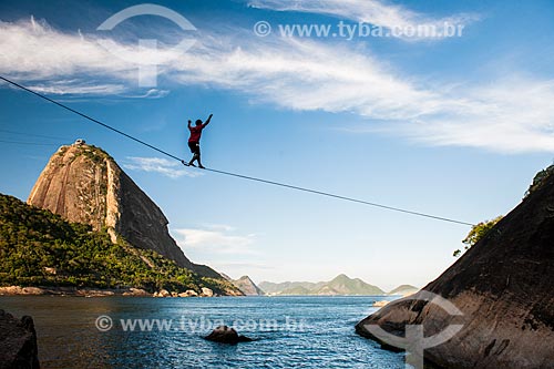  Practitioner of slackline - hill near to Vermelha Beach (Red Beach) with Sugar Loaf in the background  - Rio de Janeiro city - Rio de Janeiro state (RJ) - Brazil