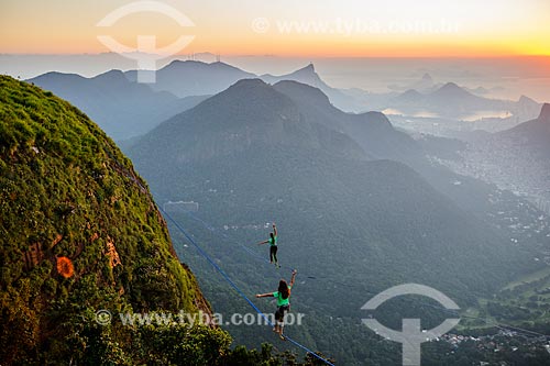  Practitioners of slackline on the top of Rock of Gavea with Tijuca National Park in the background  - Rio de Janeiro city - Rio de Janeiro state (RJ) - Brazil