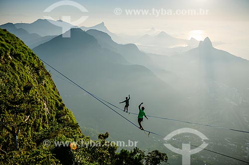  Practitioners of slackline on the top of Rock of Gavea with Tijuca National Park in the background  - Rio de Janeiro city - Rio de Janeiro state (RJ) - Brazil