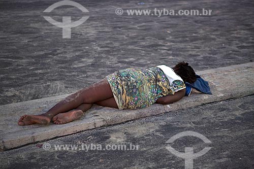  Woman sleeping - sidewalk of bike lane of the Copacabana Beach - post 6 - after the Reveillon party  - Rio de Janeiro city - Rio de Janeiro state (RJ) - Brazil