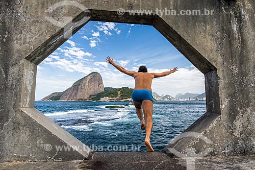  Man jumping in the Guanabara Bay from the footbridge of the Tamandare da Laje Fort (1555) with the Sugar Loaf in the background  - Rio de Janeiro city - Rio de Janeiro state (RJ) - Brazil