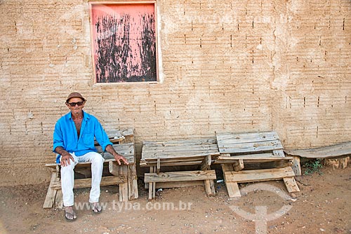  Man sitting on furniture made of scraps of wood opposite to his house near to Cacimba Nova Dam  - Custodia city - Pernambuco state (PE) - Brazil