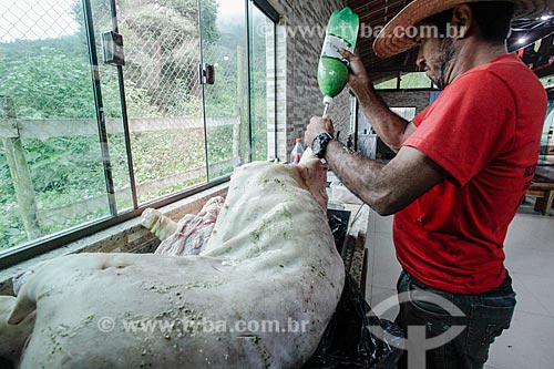  Man tempering pig for roasting - Triunfo Farm  - Marica city - Rio de Janeiro state (RJ) - Brazil