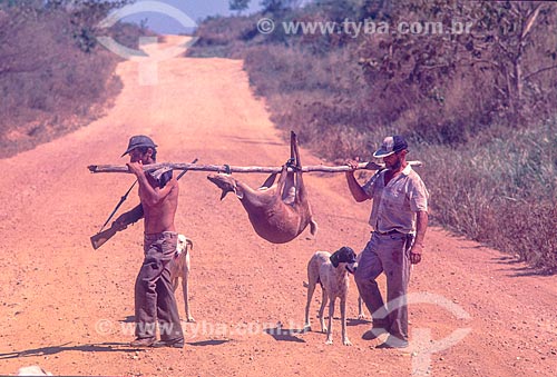  Hunters carrying slaughtered animal in amazon - 90s  - Amazonas state (AM) - Brazil