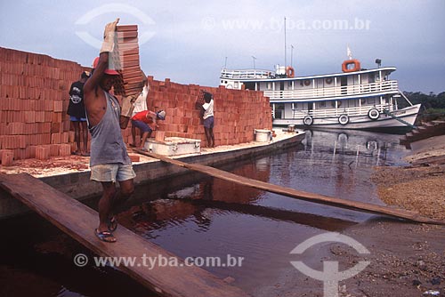  Man unloading bricks - ferry on the banks of Solimoes River - 90s  - Santa Isabel do Rio Negro city - Amazonas state (AM) - Brazil