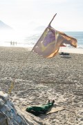 Homeless man sleeping on the sand of Copacabana Beach with the Brazilian flag in the foreground - Rio de Janeiro city - Rio de Janeiro state (RJ) - Brazil