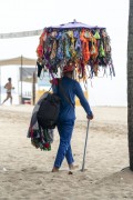 Street vendor with improvised sun umbrella as a display for selling bikinis on Copacabana Beach - Rio de Janeiro city - Rio de Janeiro state (RJ) - Brazil