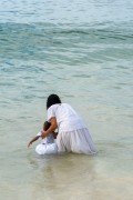 Woman with child throwing offerings for Yemanja During the party on the day of the Queen of the Sea - Arpoador Beach - Rio de Janeiro city - Rio de Janeiro state (RJ) - Brazil