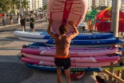 Man carrying stand-up paddleboards at Posto 6 on Copacabana Beach - Rio de Janeiro city - Rio de Janeiro state (RJ) - Brazil
