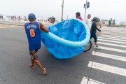 Men carrying an inflatable pool on the shore of Copacabana Beach. - Rio de Janeiro city - Rio de Janeiro state (RJ) - Brazil