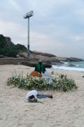 Offerings for Yemanja and a person sleeping on the sand during the party on the day of the Queen of the Sea - Arpoador Beach - Rio de Janeiro city - Rio de Janeiro state (RJ) - Brazil