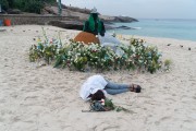Offerings for Yemanja and a person sleeping on the sand during the party on the day of the Queen of the Sea - Arpoador Beach - Rio de Janeiro city - Rio de Janeiro state (RJ) - Brazil